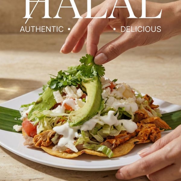 A hand garnishes a tostada with cilantro, topped with meat, lettuce, avocado, and cheese.