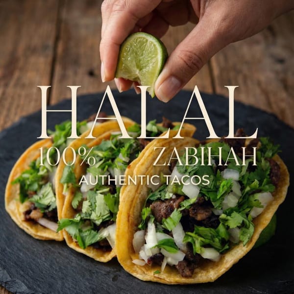 A hand squeezes lime over three halal tacos with meat, onions, and cilantro on a dark slate.